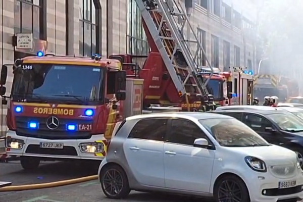 Bomberos trabajan en la extinción de un incendio declarado en un edificio en Ciudad Lineal