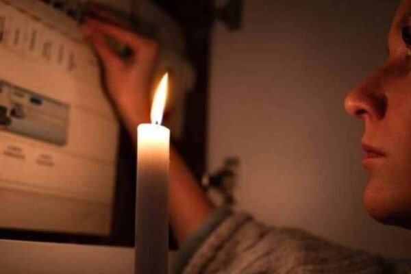 Mujer con vela durante corte de luz en Madrid por apagones programados.