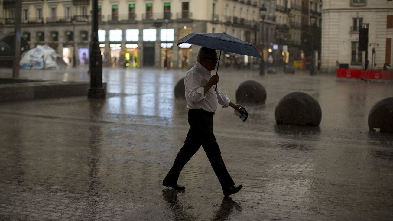 Hombre con paraguas por la calle de Madrid