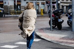 Una mujer cruza una calle de Madrid con viento